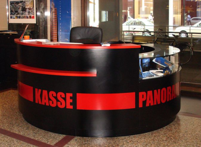 Runder Kassentresen in Schwarz und Rot mit Vitrinenteil, beschriftet mit „Kasse Panoramapunkt"