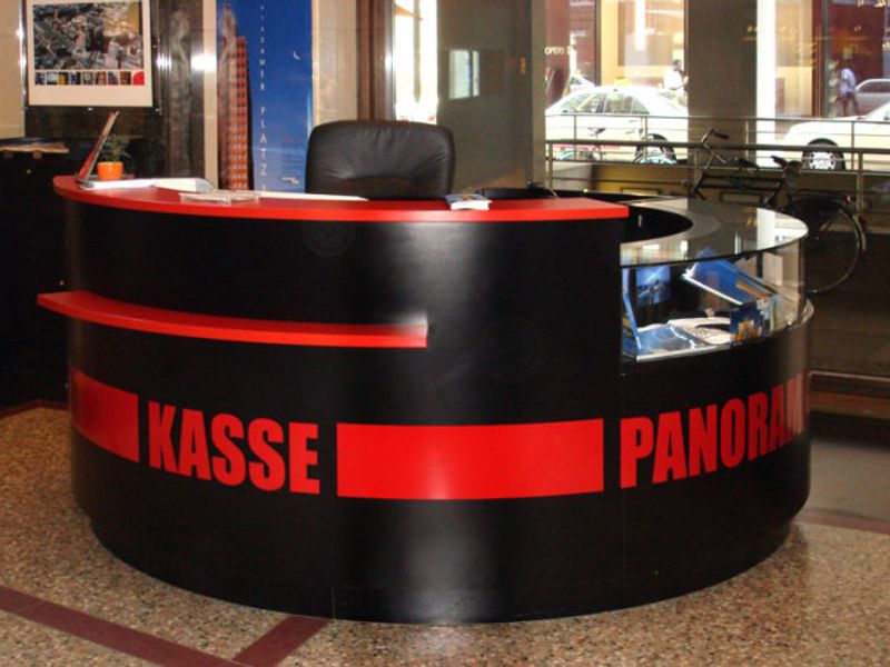 Runder Kassentresen in Schwarz und Rot mit Vitrinenteil, beschriftet mit „Kasse Panoramapunkt"