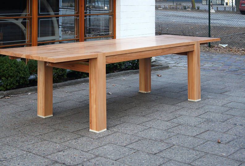 Große ausziehbare Massivholztafel mit kräftigen Vierkantbeinen, aufgestellt im Hof vor der Werkstatt