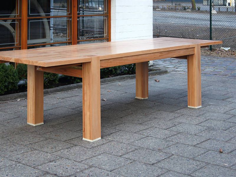 Große ausziehbare Massivholztafel mit kräftigen Vierkantbeinen, aufgestellt im Hof vor der Werkstatt