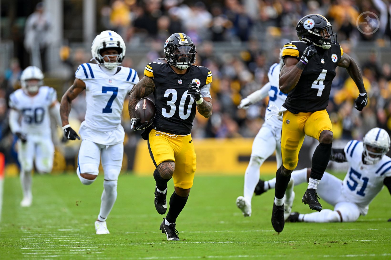 Pittsburgh Steelers running back Jaylen Warren (30) carries the ball upfield as Indianapolis Colts defenders give chase at Acrisure Stadium.