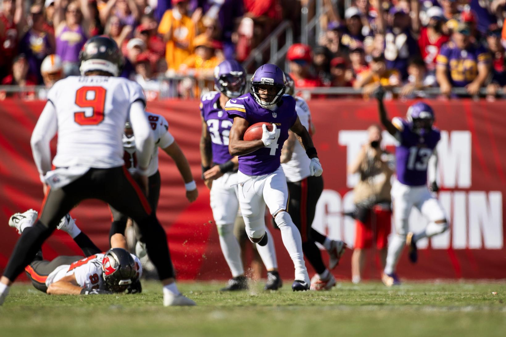 Minnesota Vikings returner Myles Price (4) runs with the football on a punt return as Tampa Bay Buccaneers punter Riley Dixon (9) closes in at Raymond James Stadium.