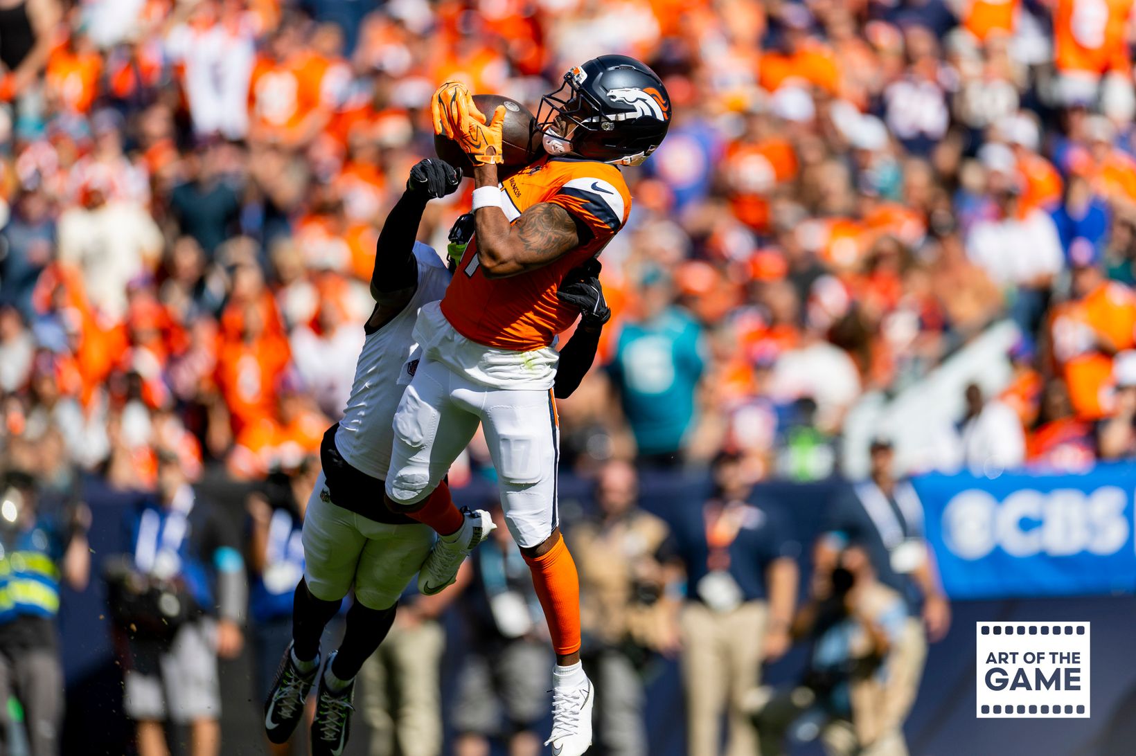 Denver Broncos wide receiver Jaylen Waddle (17) goes up for a catch over a Jacksonville Jaguars defender at Empower Field at Mile High in Denver.