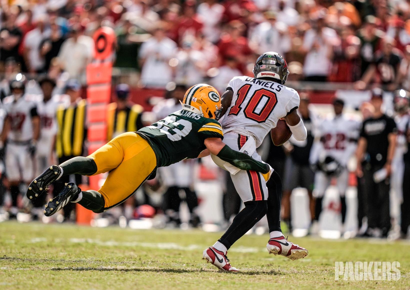 Green Bay Packers safety Evan Williams dives to wrap up Tampa Bay Buccaneers quarterback Jalon Daniels (10) in front of the Buccaneers sideline.