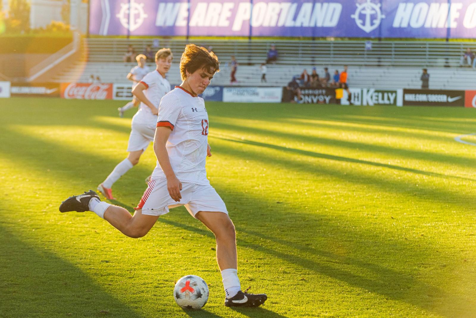 Player winds up to strike the ball at Merlo Field in golden light — Photo Credit: Aaron Leopold/Undrafted