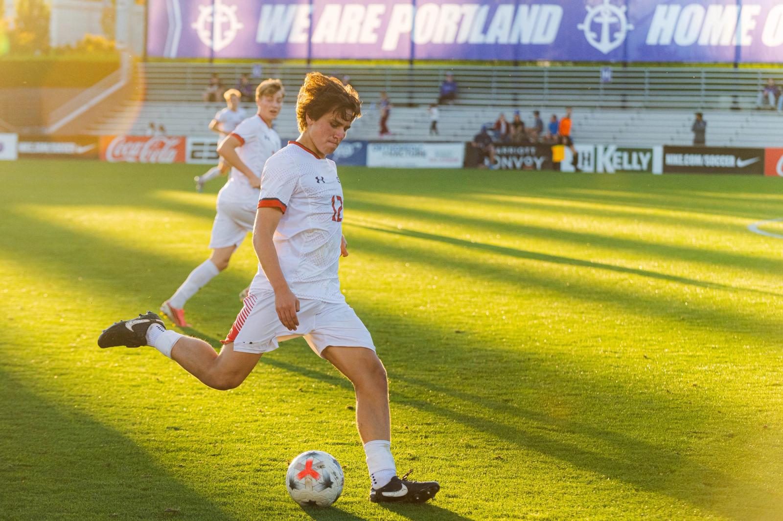 Player winds up to strike the ball at Merlo Field in golden light — Photo Credit: Aaron Leopold/Undrafted