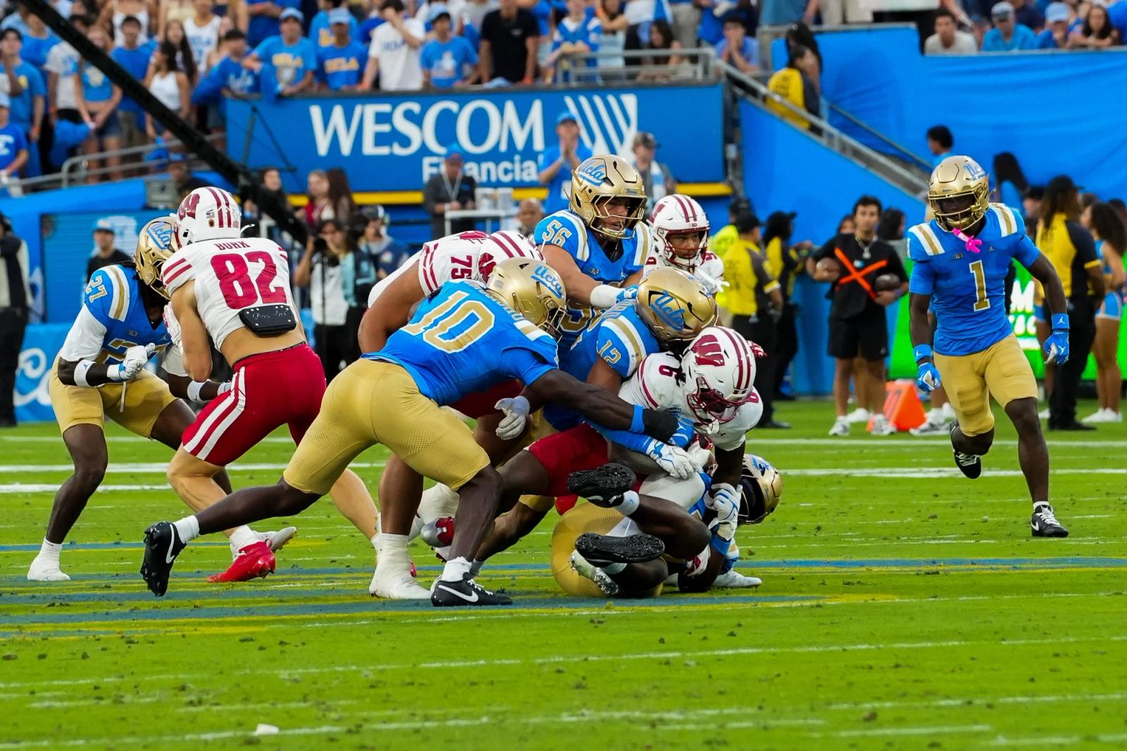 UCLA defenders tackle a Wisconsin ball carrier at the Rose Bowl