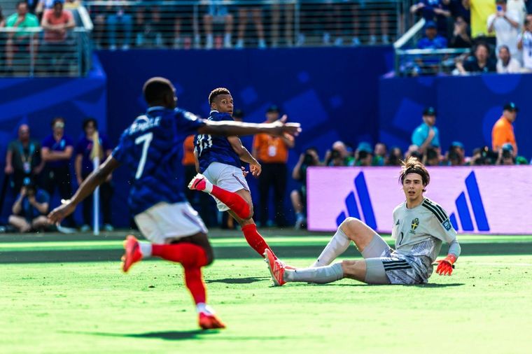 Kylian Mbappé shoots as Sweden's goalkeeper is beaten during France's World Cup Round of 32 win