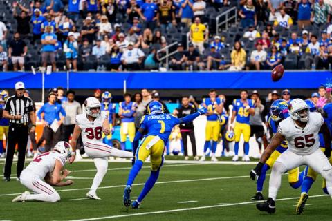 Arizona Cardinals kicker Chad Ryland (38) follows through on a field goal attempt as the ball sails away and a Los Angeles Rams defender lunges to try to block it.