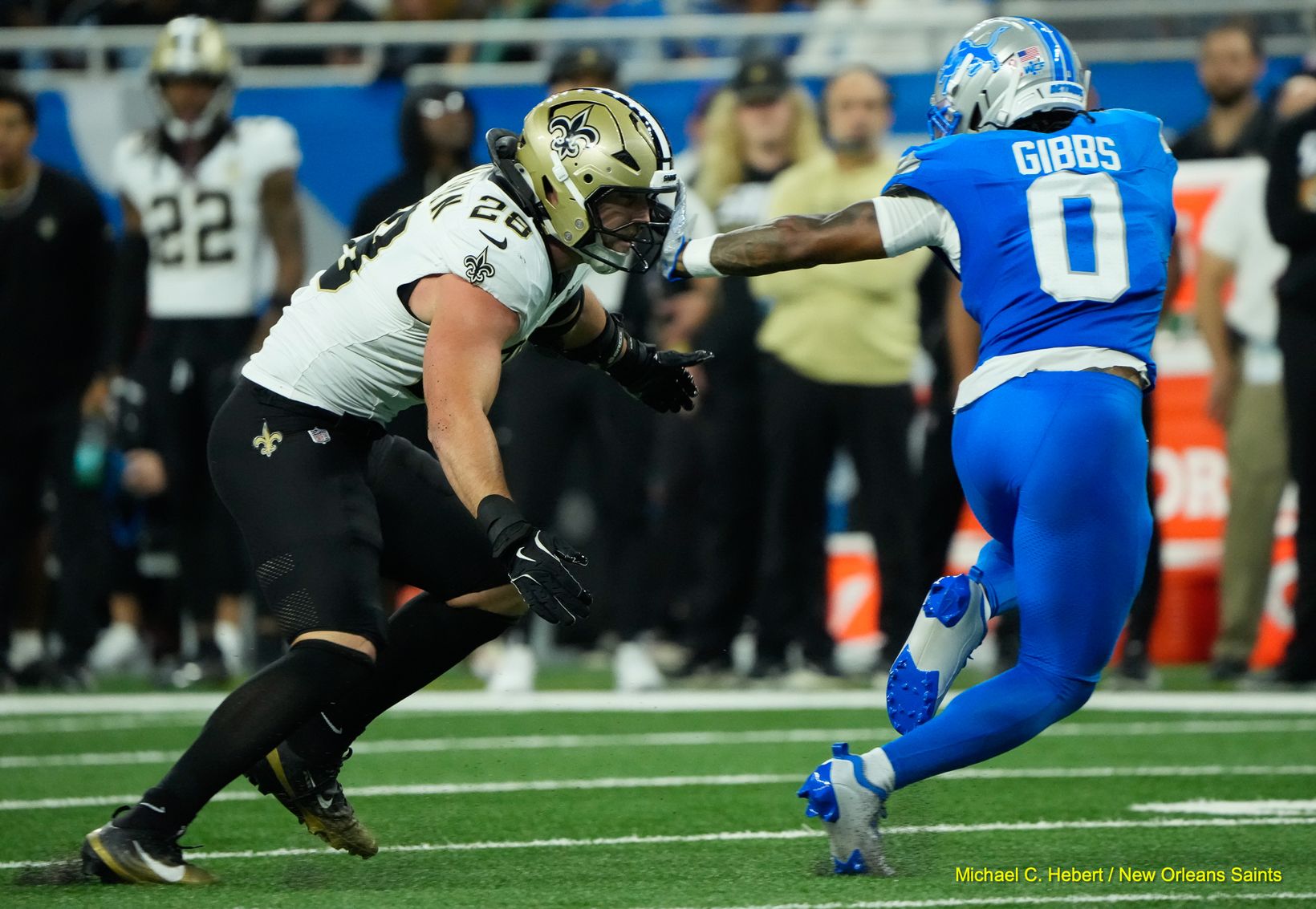 Detroit Lions running back Jahmyr Gibbs (0) extends a stiff arm toward New Orleans Saints defender Danny Stutsman (28) at Ford Field.
