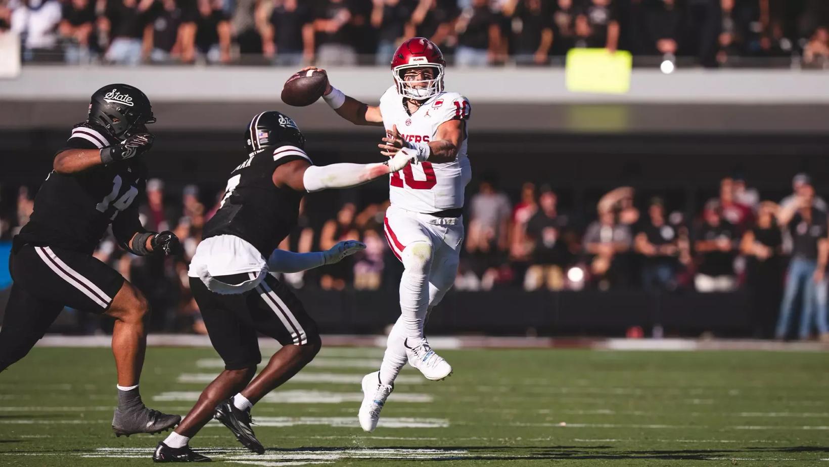 Oklahoma quarterback John Mateer throws on the run as two Mississippi State defenders close in during the Sooners' 23-15 win at Davis Wade Stadium in Starkville on October 24, 2026.