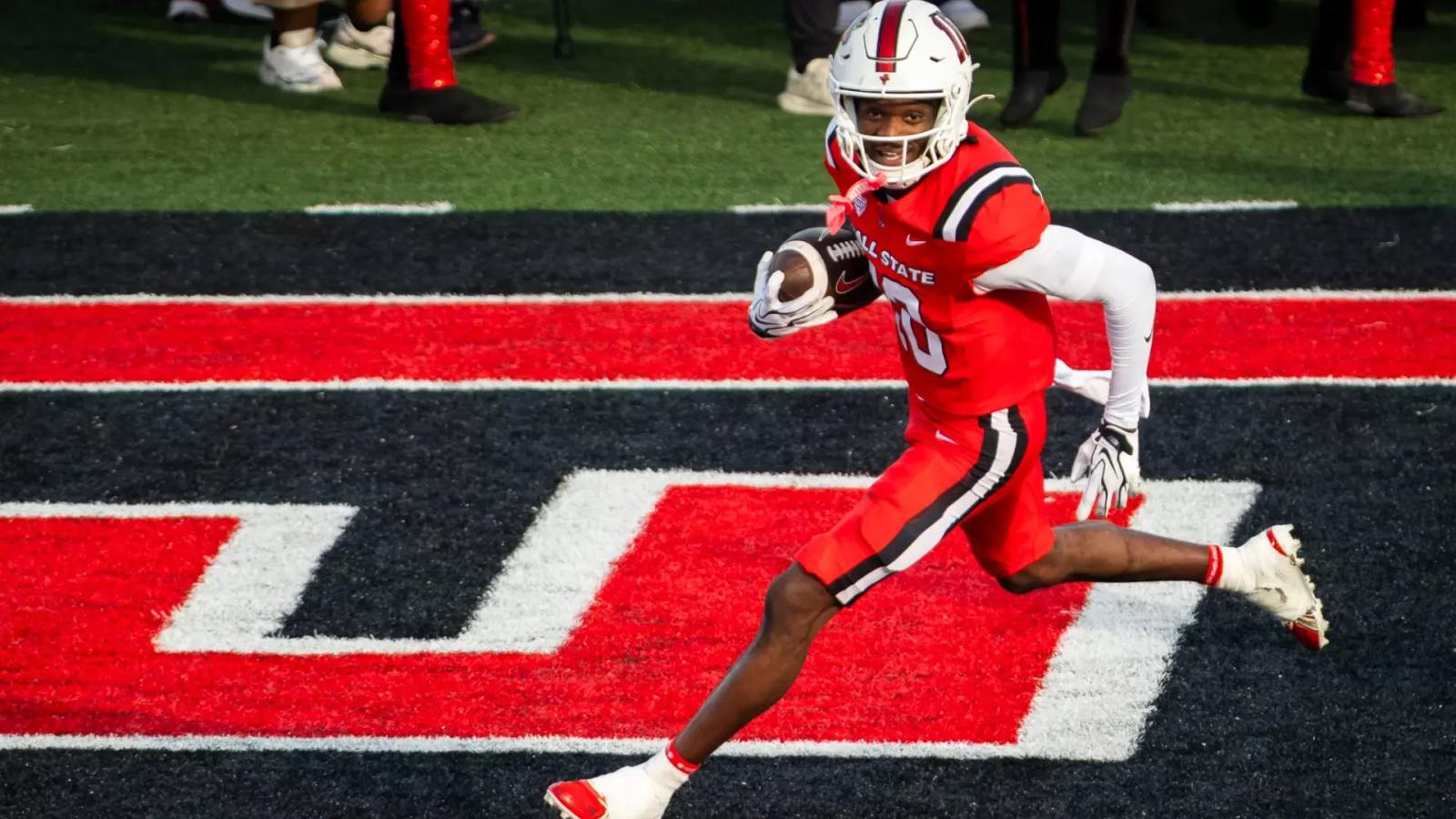 Ball State's No. 10, in a red uniform and white helmet, carries the ball through the end zone during the homecoming game against Sacramento State at Scheumann Stadium on Oct. 24, 2026.