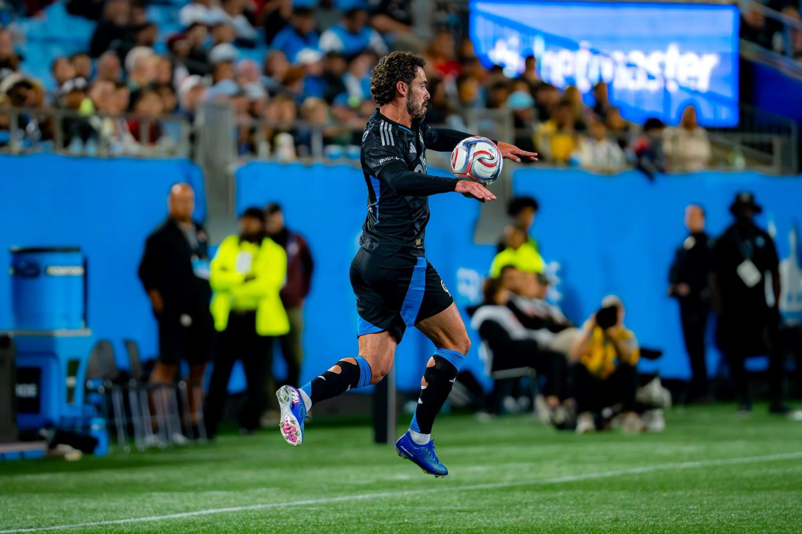 A Charlotte FC player leaps to control the ball near the touchline against CF Montréal at Bank of America Stadium — Photo Credit: Arturo Rosales Sevilla/Undrafted
