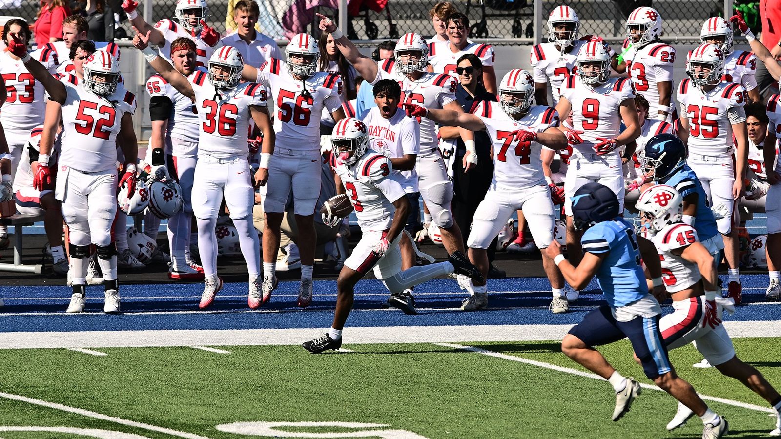 Dayton's LeRoy Lewis IV runs back a kickoff along the Dayton sideline as teammates in white celebrate and San Diego players in light blue chase on Oct. 24, 2026