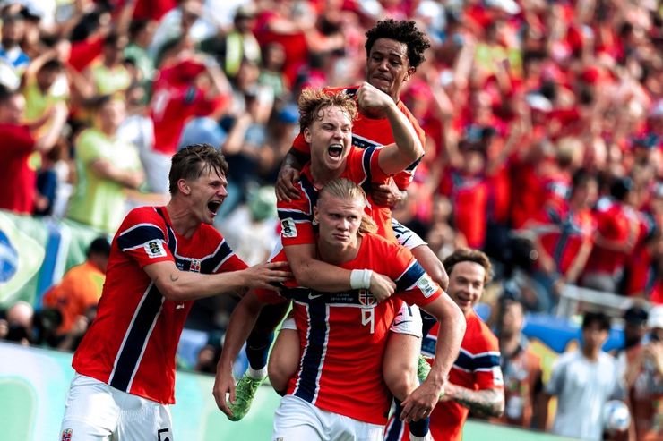 Erling Haaland carries a teammate on his back as Norway celebrate a goal against Brazil in the World Cup Round of 16