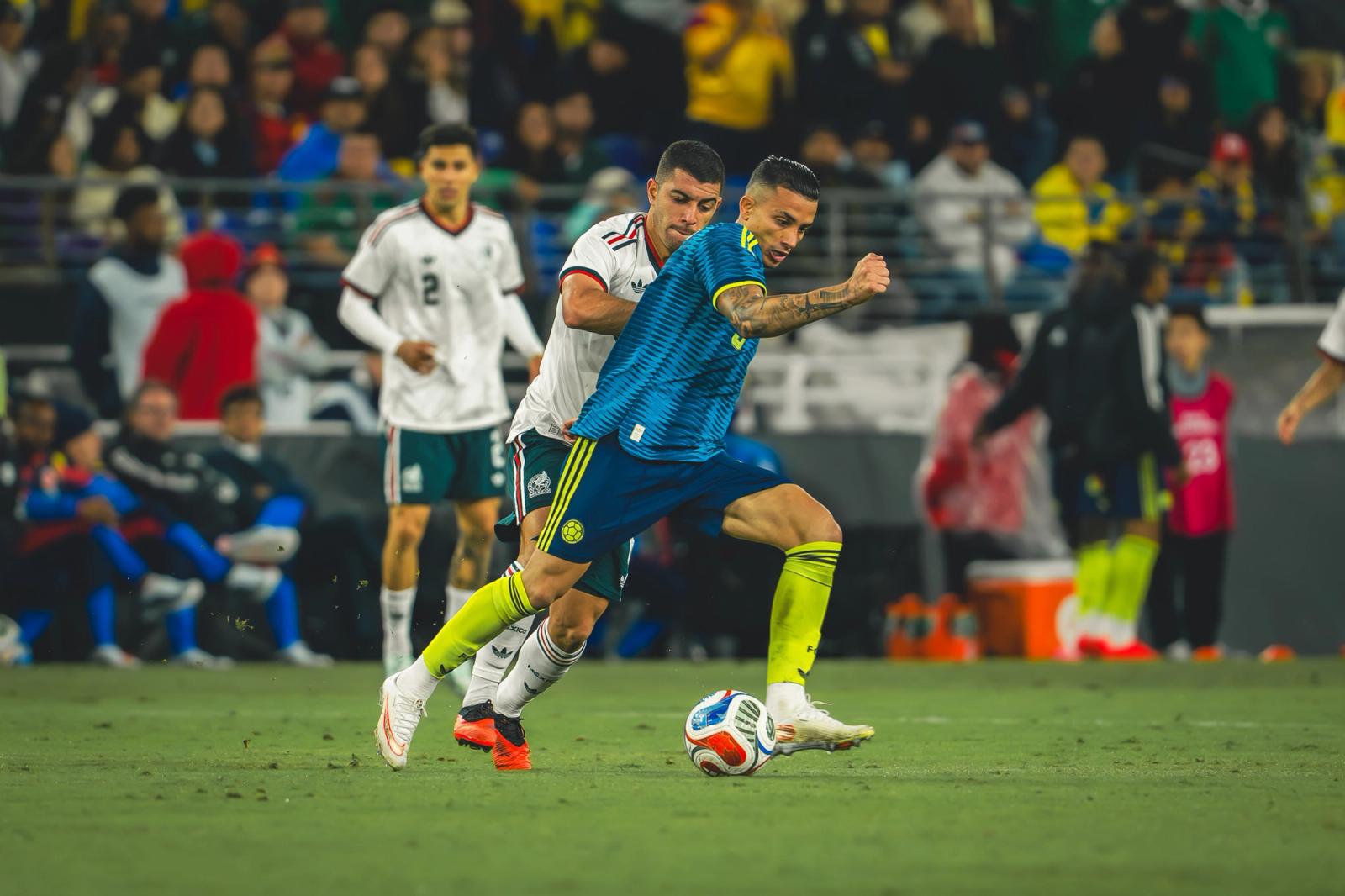 Colombia player dribbles under pressure from a Mexico defender — Photo Credit: Arturo Rosales Sevilla/Undrafted