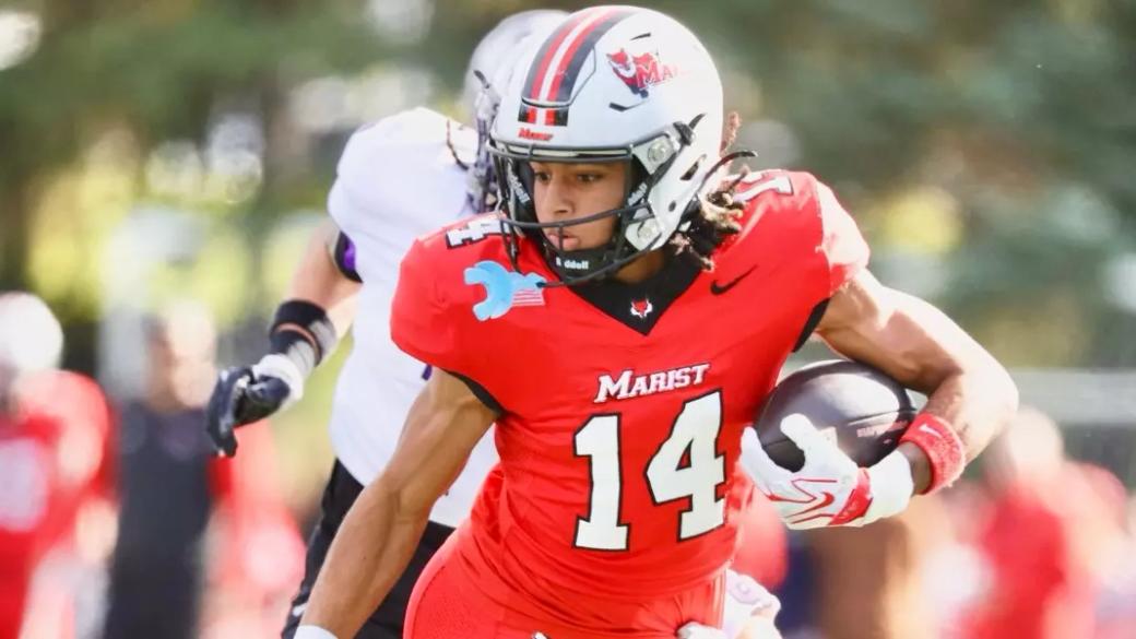 Marist receiver Jayden Taylor, wearing No. 14 in red, carries the ball as a St. Thomas defender in white and purple pursues at Tenney Stadium on Oct. 24, 2026