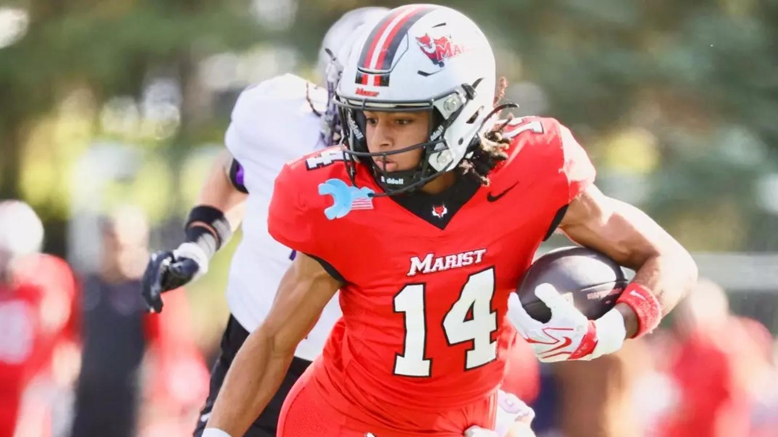 Marist receiver Jayden Taylor, wearing No. 14 in red, carries the ball as a St. Thomas defender in white and purple pursues at Tenney Stadium on Oct. 24, 2026