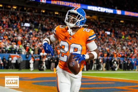 Denver Broncos cornerback Ja'Quan McMillian (29) holds the football in the end zone as a stadium ribbon board behind him reads Interception.
