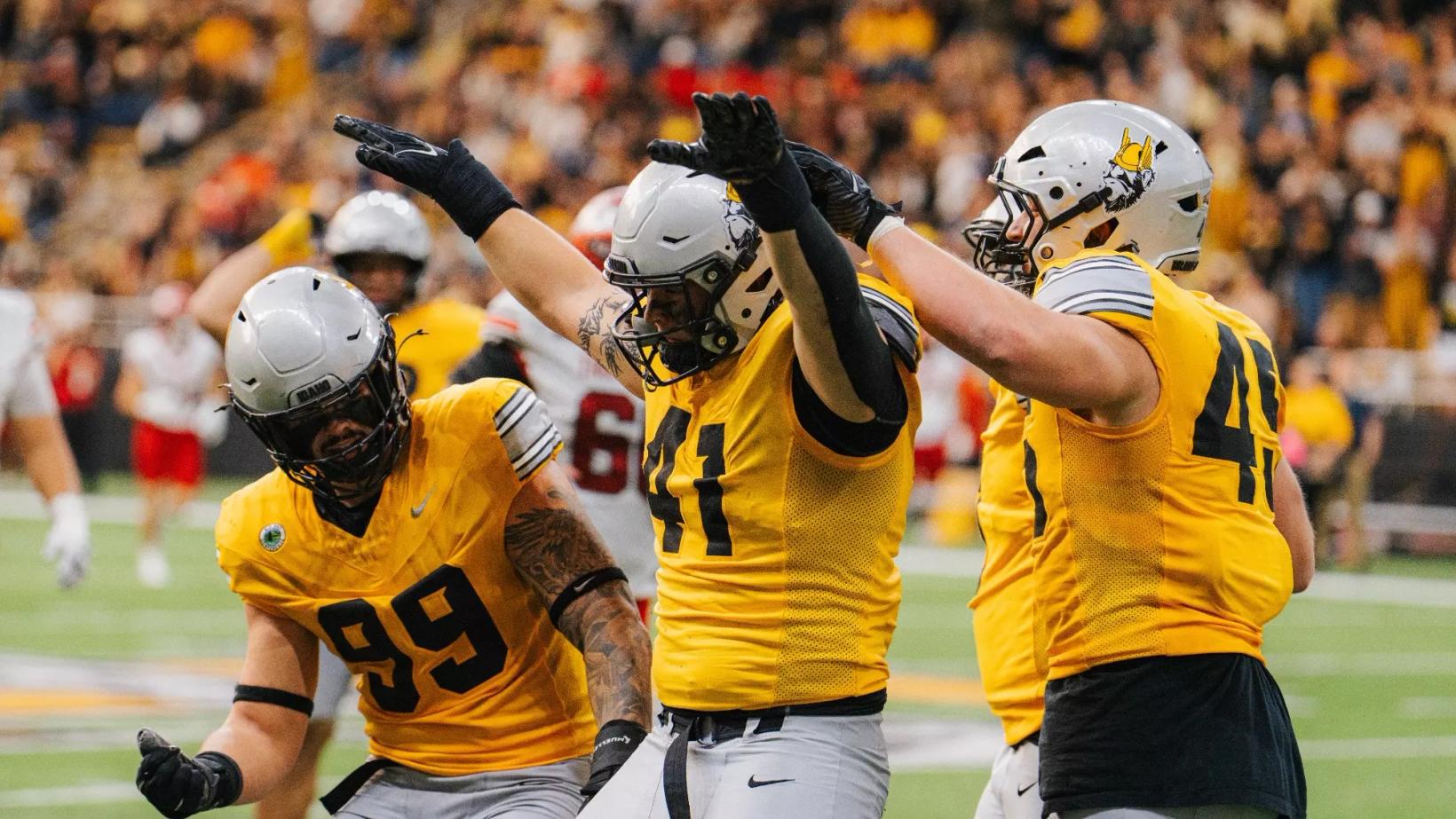 Idaho defenders in gold jerseys celebrate with arms raised inside the Kibbie Dome during the Vandals' 31-28 Homecoming win over Southern Utah on Oct. 24, 2026