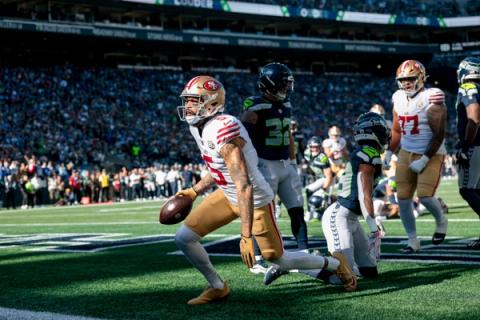 San Francisco 49ers wide receiver Mike Evans (5) holds the ball in the end zone as Seattle Seahawks defenders look on at Lumen Field