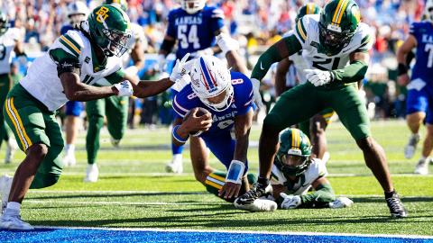 Kansas quarterback Isaiah Marshall dives toward the goal line between Baylor defenders on his late touchdown run.