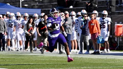 Holy Cross running back Jojo Williams carries the ball down the sideline past the Bucknell bench at Fitton Field during Holy Cross's 34-3 Homecoming win on Oct. 24, 2026
