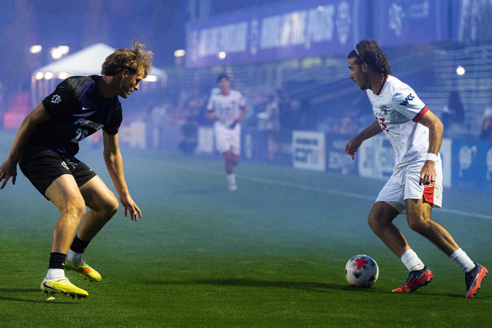 Attacker dribbles against a defender under Merlo Field lights — Photo Credit: Aaron Leopold/Undrafted