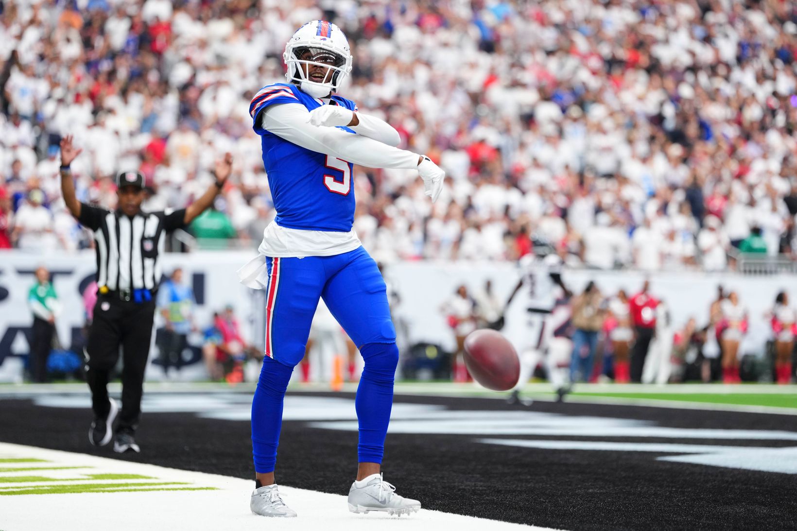Buffalo Bills receiver Joshua Palmer (5) celebrates in the end zone with the ball bouncing beside him while an official signals touchdown in the background.