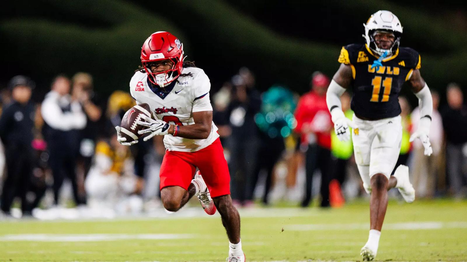 Liberty running back Jaylon Coleman, in a white jersey and red helmet, carries the ball upfield with a Kennesaw State defender in pursuit on his 56-yard touchdown catch at Fifth Third Stadium on Oct. 22, 2026.