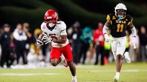 Liberty running back Jaylon Coleman, in a white jersey and red helmet, carries the ball upfield with a Kennesaw State defender in pursuit on his 56-yard touchdown catch at Fifth Third Stadium on Oct. 22, 2026.