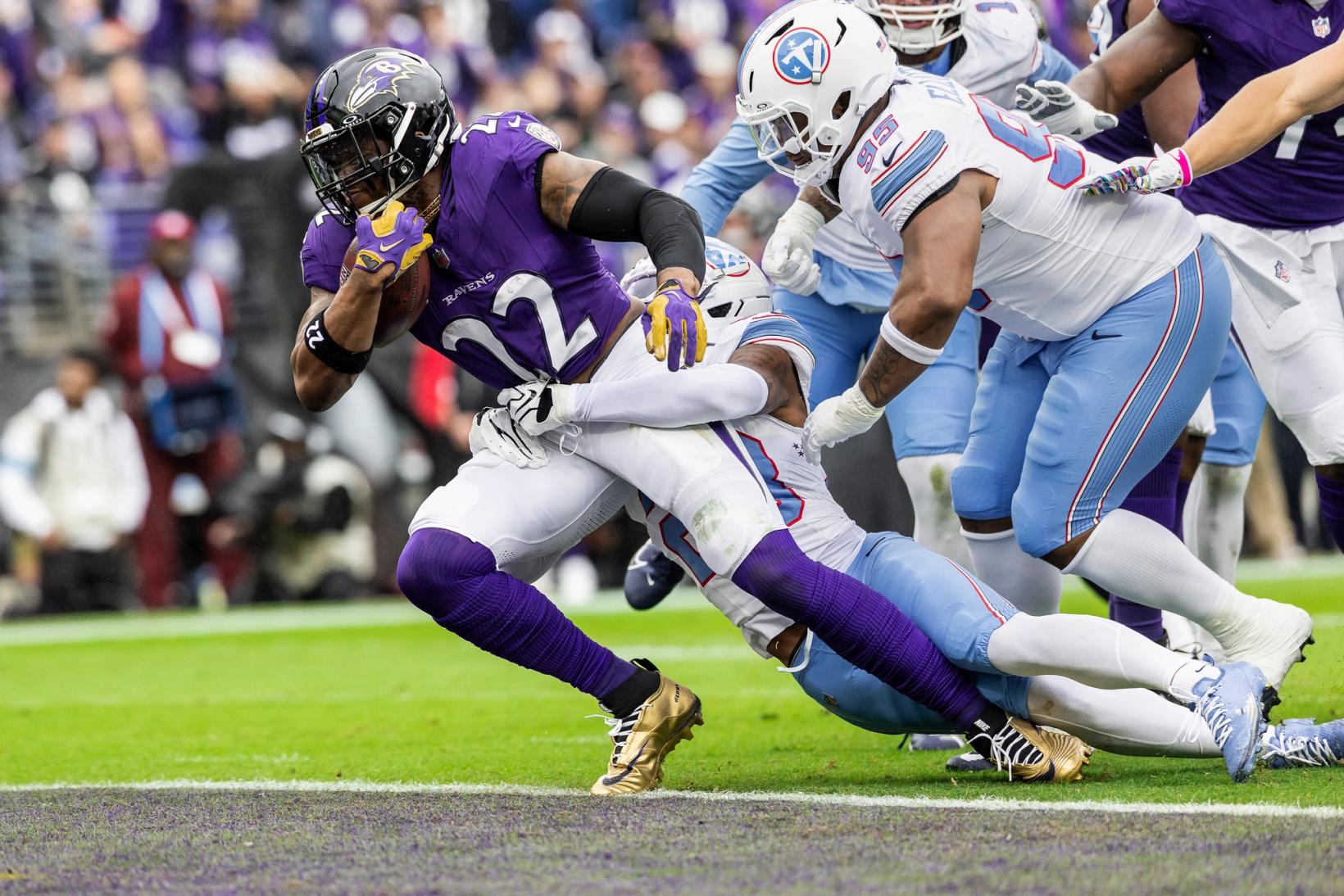 Baltimore Ravens running back Derrick Henry (22) carries the ball near the goal line as a Tennessee Titans defender wraps him up at M&T Bank Stadium.