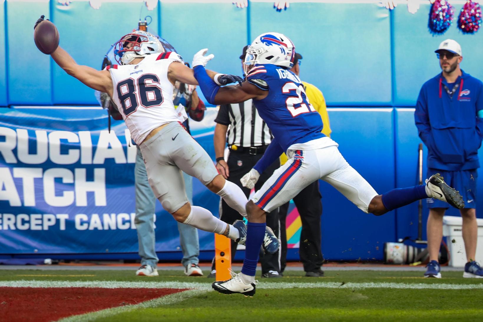New England Patriots receiver Efton Chism III (86) stretches out his right arm for a one-handed catch near the sideline as Buffalo Bills defender Davison Igbinosun reaches in.