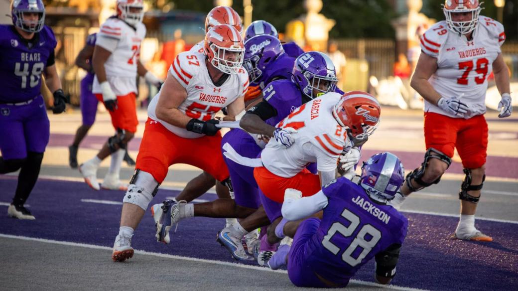 Central Arkansas defenders in purple tackle a UTRGV ball carrier in a white jersey near the goal line at Estes Stadium in Conway, Oct. 24, 2026