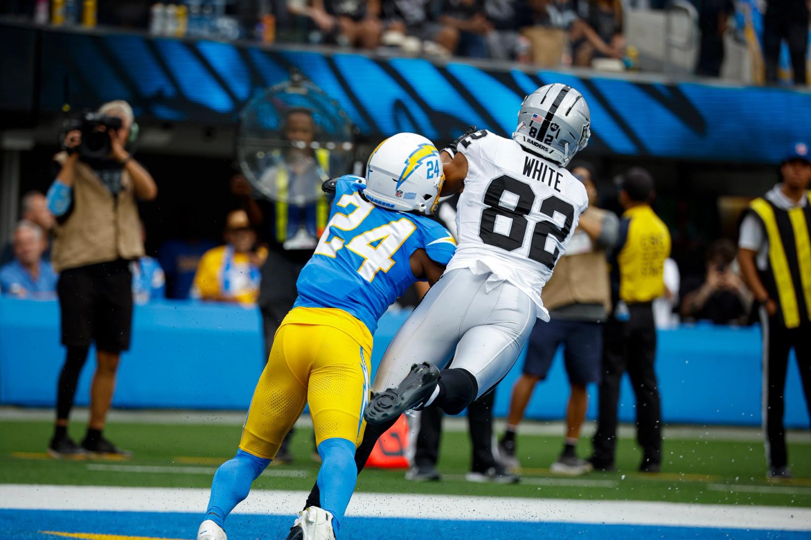 Las Vegas Raiders wide receiver Cody White (82) hauls in a pass near the goal line while covered by a Los Angeles Chargers defender at SoFi Stadium.