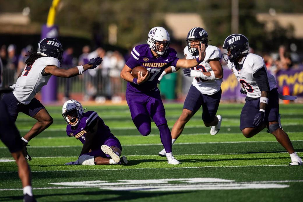 Western Illinois quarterback Kennedy McGill carries the ball as UT Martin defenders in white jerseys close in at Hanson Field in Macomb, Oct. 24, 2026