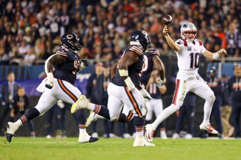New England Patriots quarterback Drake Maye, wearing No. 10, releases a pass as Chicago Bears defenders rush toward him.