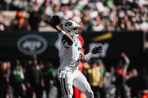 New York Jets quarterback Geno Smith (7) cocks his arm to throw, with a Jets logo on the video board behind him.