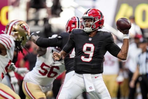 Atlanta Falcons quarterback Michael Penix Jr. (9) winds up to pass as San Francisco 49ers defenders, including No. 56, rush toward him.