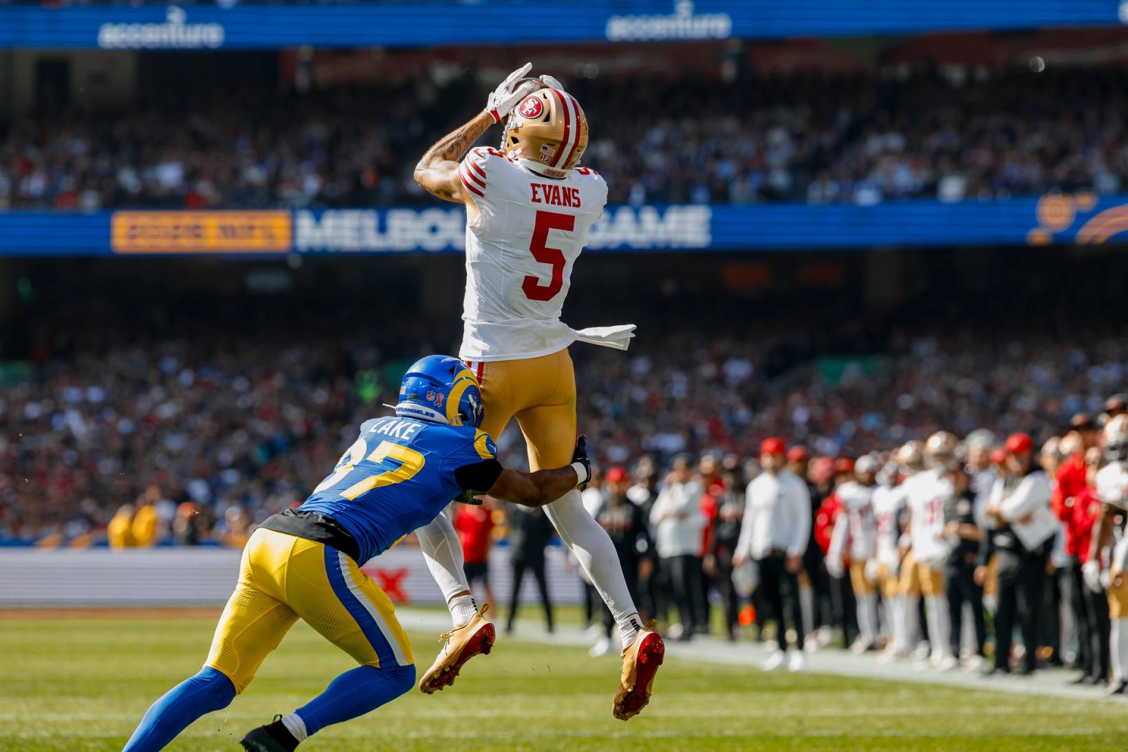 San Francisco 49ers wide receiver Mike Evans (5) leaps to catch a pass over Los Angeles Rams defender Quentin Lake (37) at the Melbourne Cricket Ground.