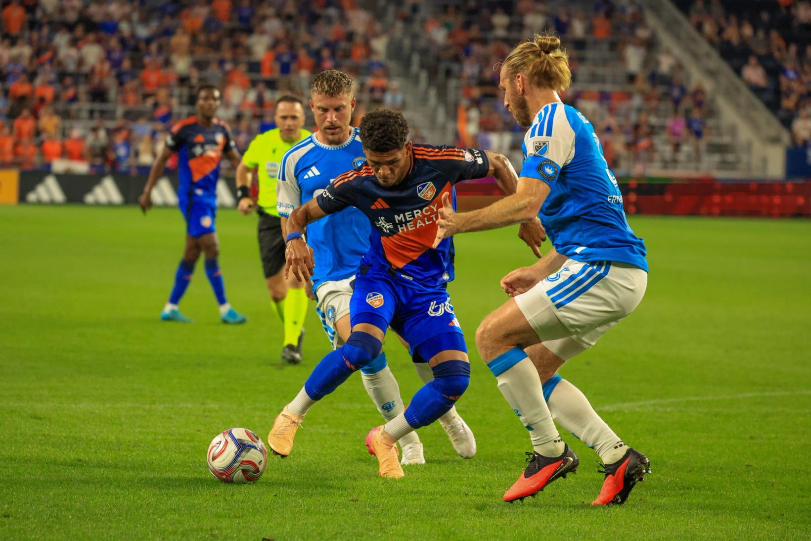 FC Cincinnati's Dado Valenzuela shields the ball from Charlotte FC defender Tim Ream during the September 12, 2026 match at TQL Stadium.