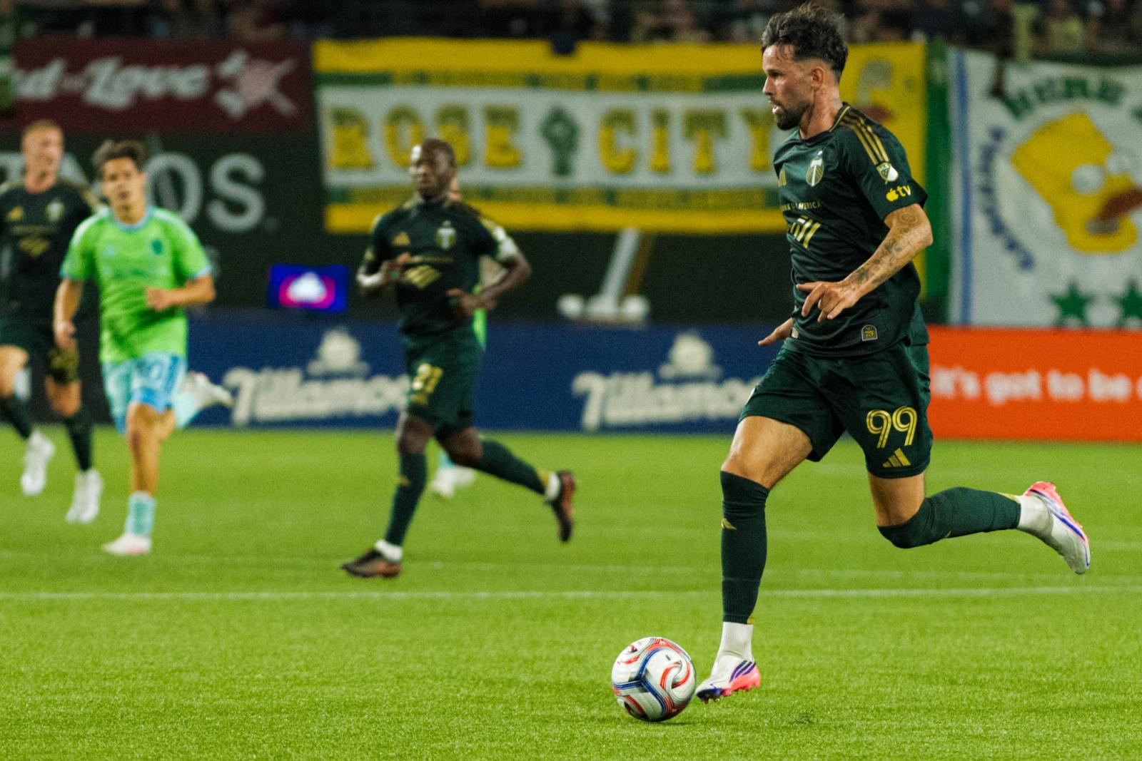 Portland Timbers winger Kristoffer Velde dribbles past a Seattle Sounders defender during the August 1, 2026 MLS match at Providence Park, with a Rose City tifo displayed behind the goal.