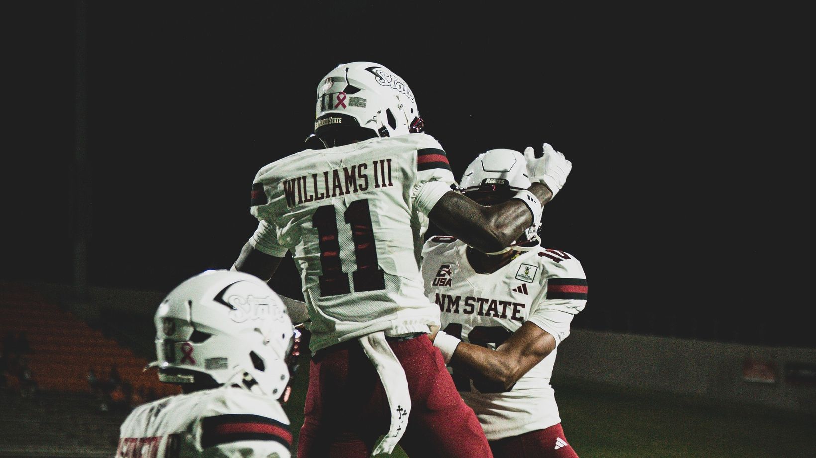 New Mexico State wide receiver AJ Williams III, No. 11, leaps to celebrate a touchdown with teammates during the Aggies' 30-24 win over Sam Houston at Bowers Stadium in Huntsville, Texas, on Oct. 21, 2026.