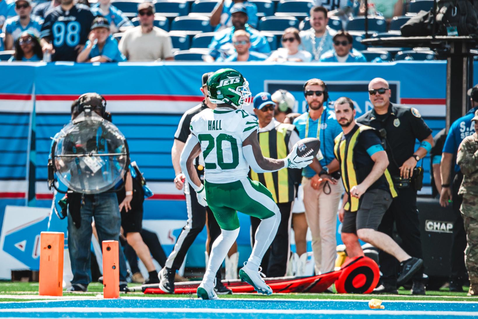 New York Jets running back Breece Hall (20) holds the football near the end zone pylons at Nissan Stadium as sideline staff and fans look on