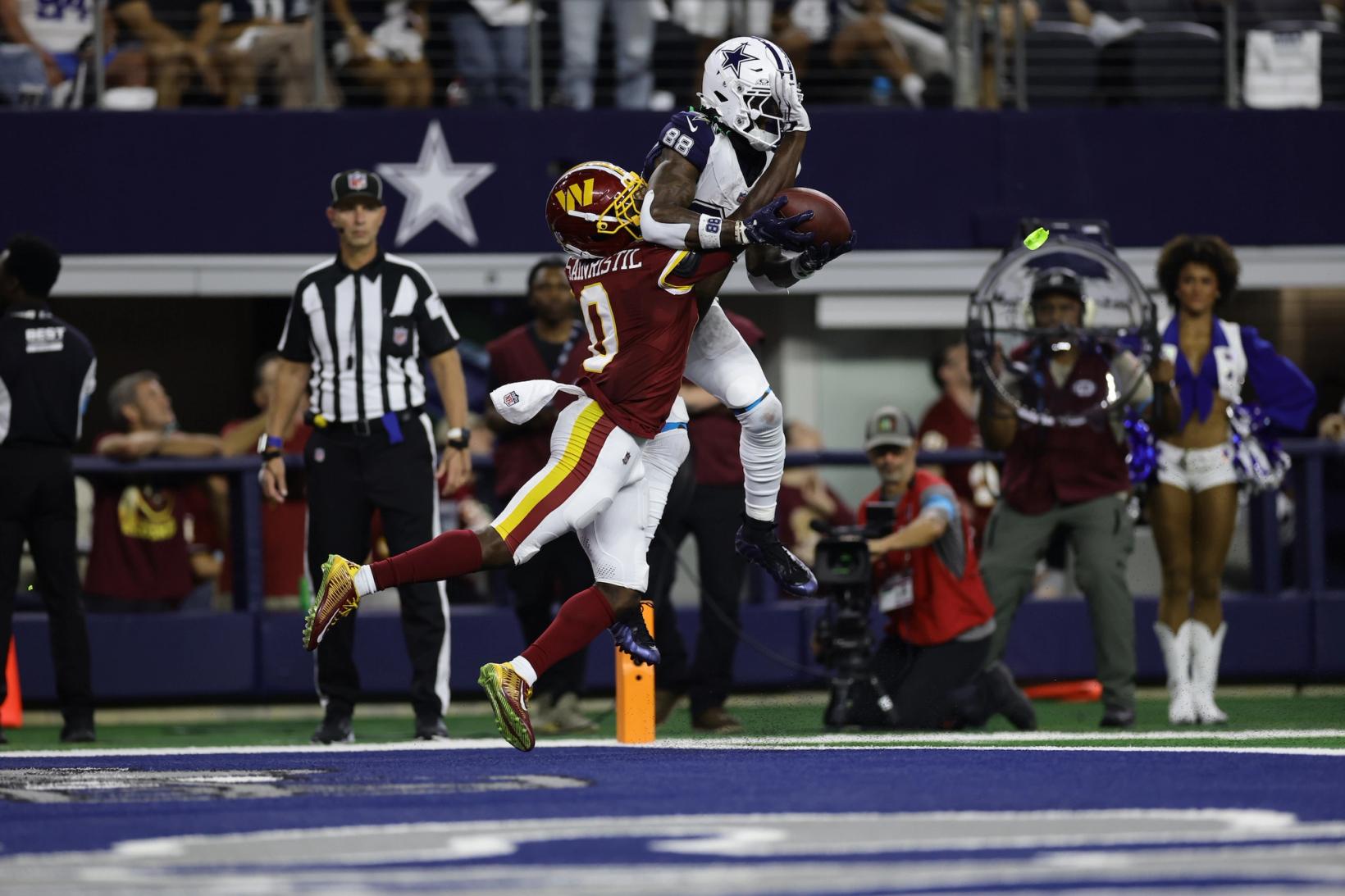 Dallas Cowboys wide receiver CeeDee Lamb (88) catches a pass in the end zone over a Washington Commanders defender at AT&T Stadium in Arlington, Texas.