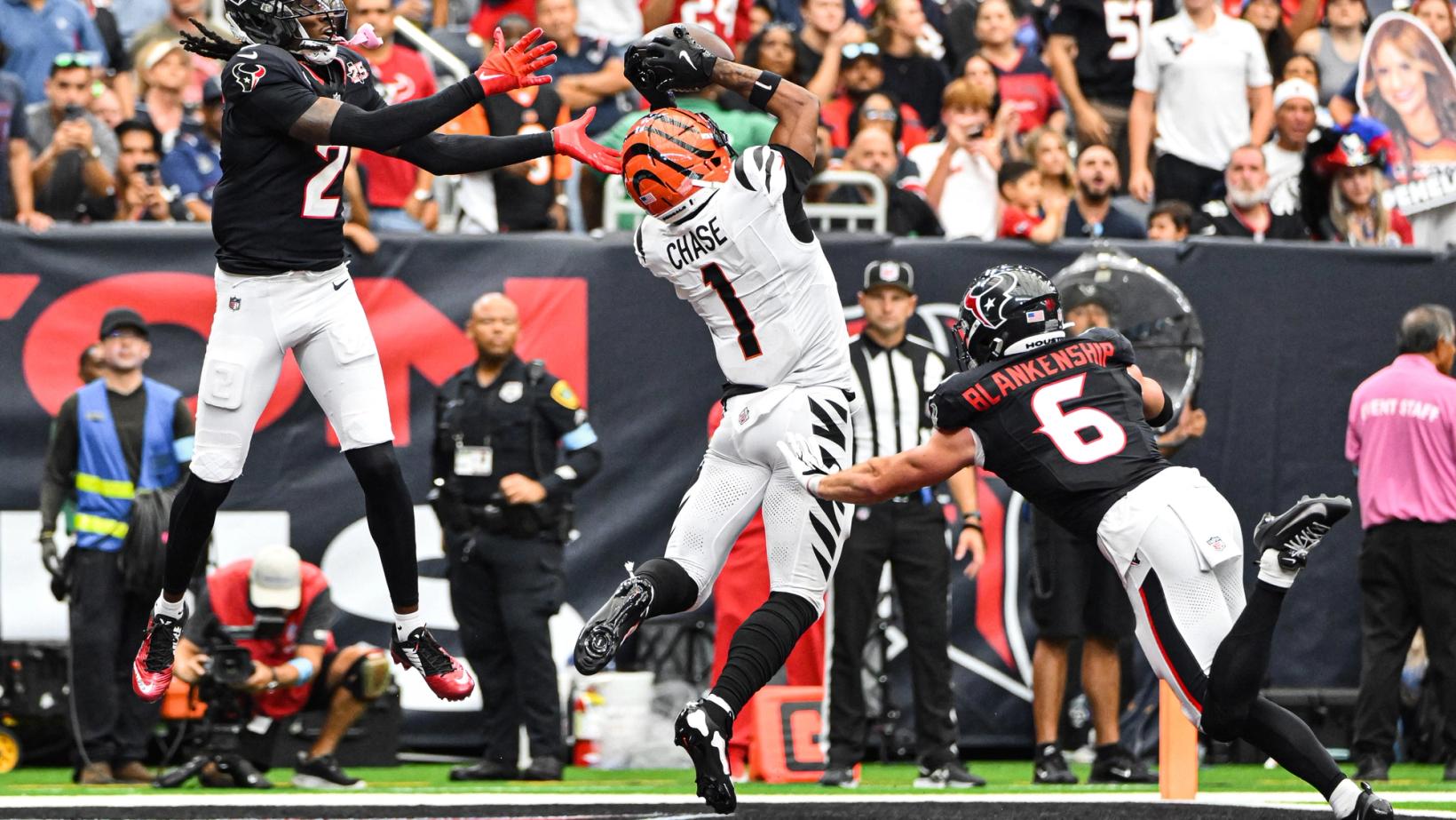 Cincinnati Bengals wide receiver Ja'Marr Chase (1) leaps to catch a pass near the pylon as two Houston Texans defenders close in.