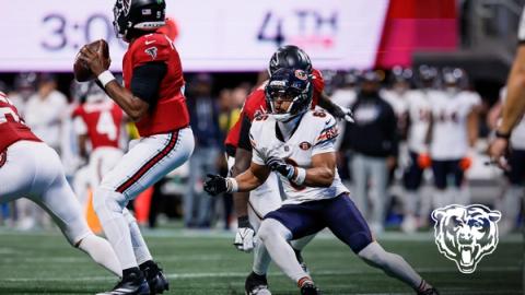Chicago Bears cornerback Kyler Gordon (6) closes in on Atlanta Falcons quarterback Michael Penix Jr. (9) as the scoreboard behind them shows the fourth quarter.