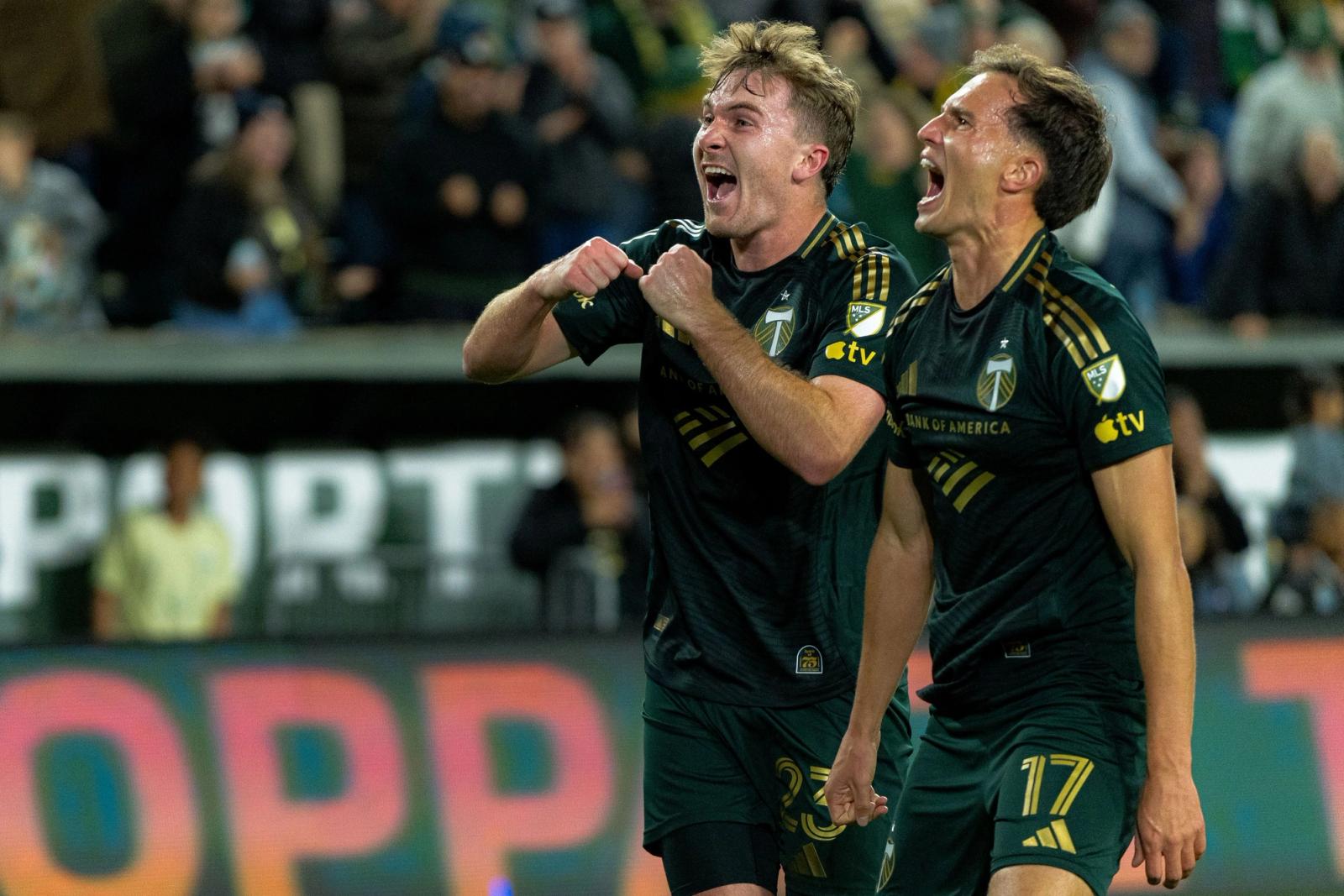 Two Portland Timbers players celebrate in front of the crowd at Providence Park during the match against Charlotte FC on October 24, 2026.