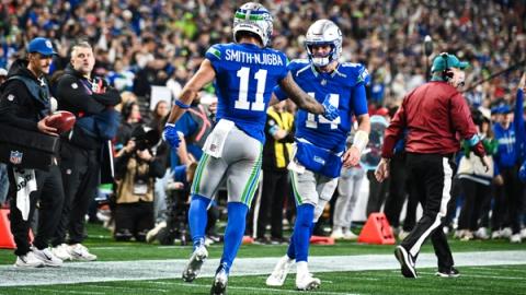 Seattle Seahawks wide receiver Jaxon Smith-Njigba (11) walks toward quarterback Sam Darnold (14) to celebrate near the sideline at Lumen Field.