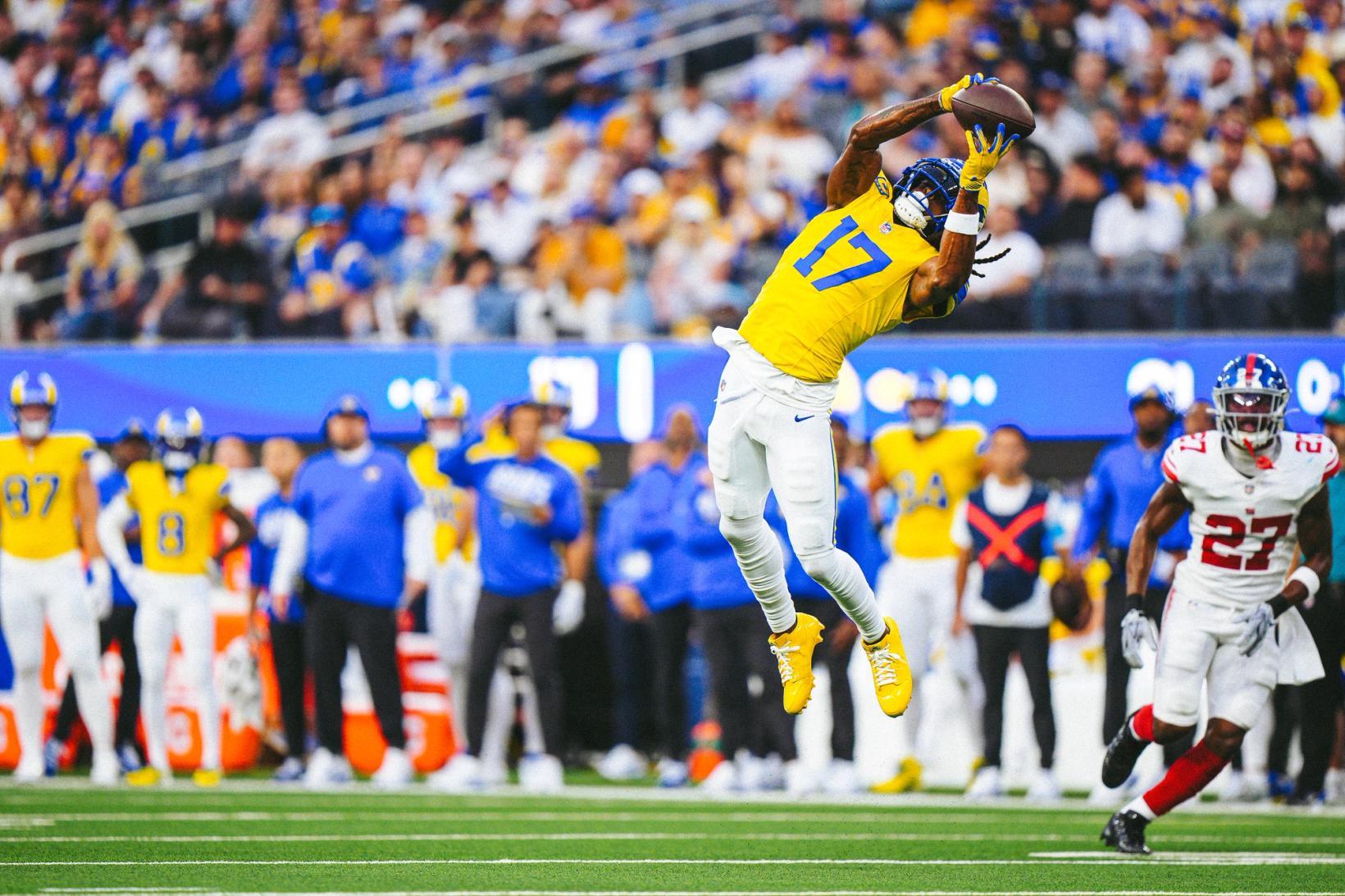 Los Angeles Rams wide receiver Davante Adams (17) leaps to catch a pass above his head as New York Giants defender Tyler Nubin (27) closes in at SoFi Stadium